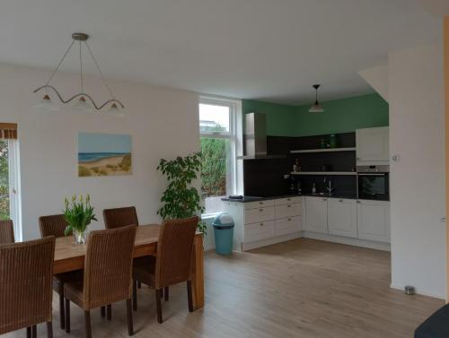 a kitchen and dining room with a table and chairs at Het Dijkstuk in Noordwijkerhout