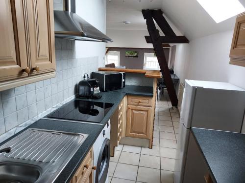 a small kitchen with a sink and a microwave at A 2 pas de la gare in Chalons en Champagne