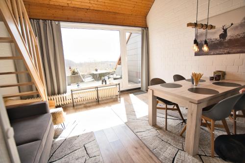 ein Esszimmer mit einem Tisch und einem großen Fenster in der Unterkunft Traumblick in Sankt Andreasberg
