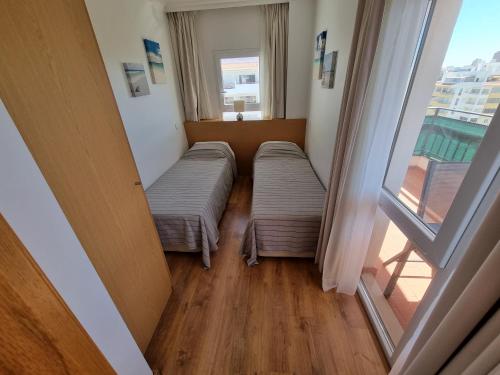 Duas camas num quarto com uma janela em Brisa Atlântica em Portimão