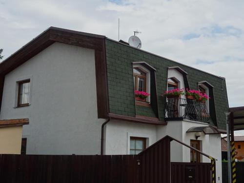 un edificio con dos ventanas con flores. en Rekreačný dom Tyrkys, en Poprad