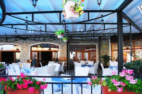 un restaurante con sillas blancas, mesas y flores en Modern, 1 Bed Apt, 4* Vineyards, en Kableshkovo