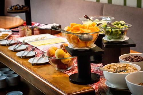 a table topped with bowls of fruit and other food at Hotel Fundador in Santiago
