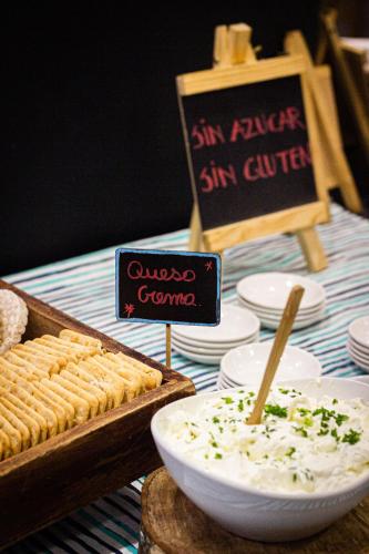 a table with a bowl of dip and a sign at Hotel Fundador in Santiago