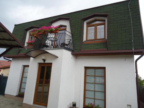 uma casa branca e verde com uma varanda em Rekreačný dom Tyrkys em Poprad