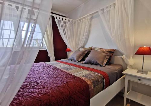 GuatizaにあるCasa Helena del Marのベッドルーム(白いカーテン付きの天蓋付きベッド1台付)