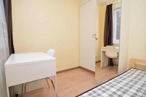 Habitación con escritorio blanco y espejo. en Pramonės av 77 Kaunas Students Home LT en Kaunas