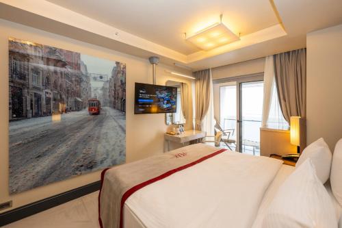 a hotel room with a bed and a painting on the wall at Ramada By Wyndham Istanbul Pera Taksim in Istanbul