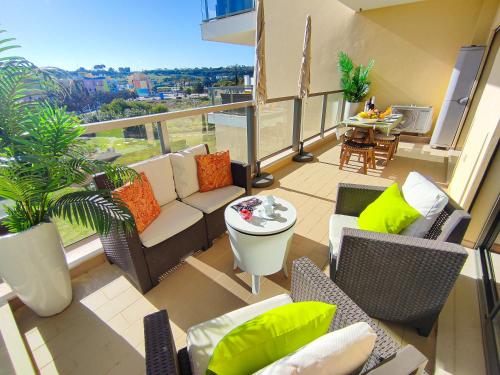 een balkon met een bank, stoelen en een tafel bij Marina Garden Palm Tree by Be Cherish in Albufeira