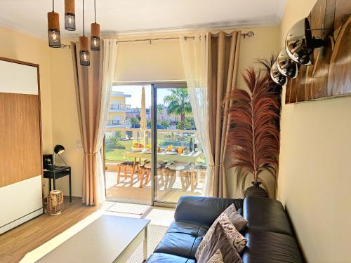 een woonkamer met een blauwe bank en een tafel bij Marina Garden Palm Tree by Be Cherish in Albufeira