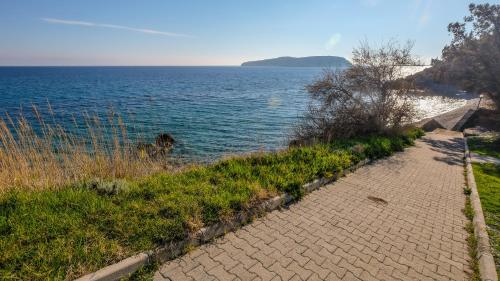 a brick path next to a body of water at Mimas Home in Hisarcık