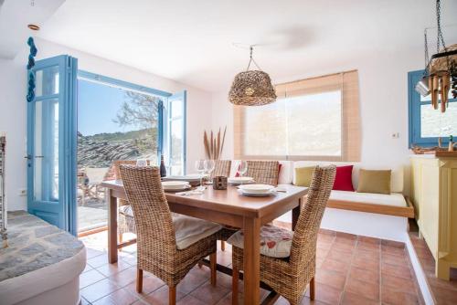 a dining room with a table and chairs and a couch at Kolimpithres beach house in Naousa