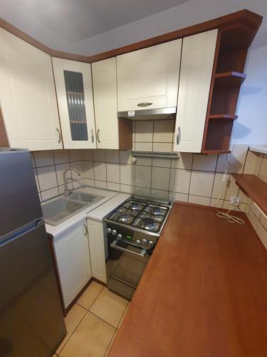 uma cozinha com armários brancos e um forno com placa de fogão em Legionów Apartament em Konin