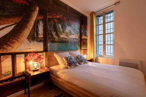 um quarto com uma cama com um quadro na parede em hawaï/parking/wifi/centre ville em Nîmes