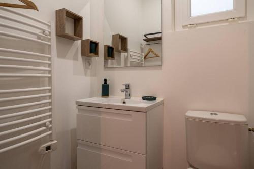 ein weißes Bad mit einem Waschbecken und einem WC in der Unterkunft hawaï parking wifi Hypercentre in Nîmes