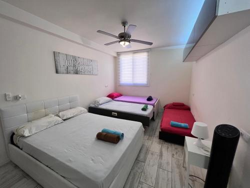 a bedroom with two beds and a ceiling fan at Golden Paradise Seaview in Adeje