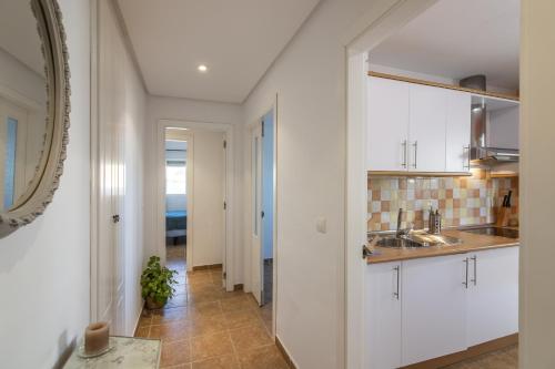 a kitchen with white cabinets and a sink at ÁTICO ATALAYA Parking privado gratis in Ayamonte