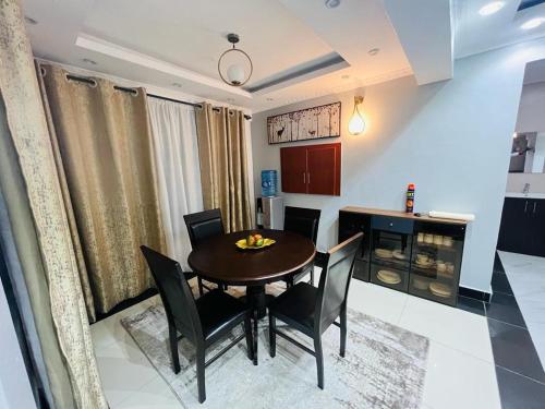 a kitchen and dining room with a table and chairs at SR Apartments Milimani, Kisumu in Kisumu