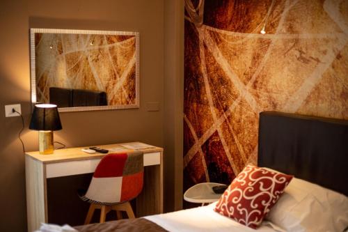 1 dormitorio con cama, escritorio y espejo en Hotel Sereno, en Sestri Levante