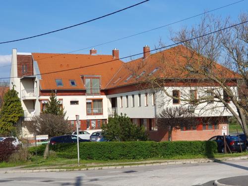 ein Gebäude mit einem orangenen Dach auf einer Straße in der Unterkunft Trend Baláca Home in Veszprém