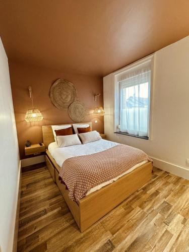 een slaapkamer met een groot bed en een raam bij Studio 2 du SPA Célinie in Warcq