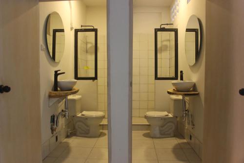 baño con 2 aseos y 2 lavabos y espejos en Casa Teresa Hotel, en Cartagena de Indias