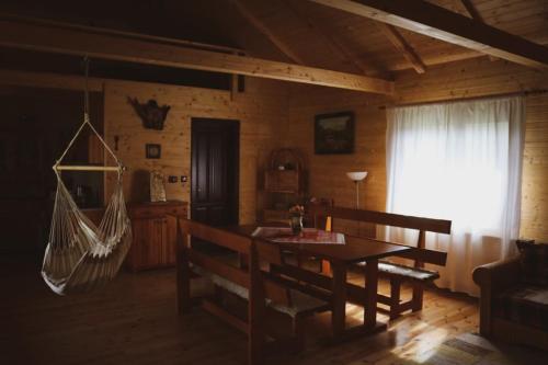 a living room with a table and chairs and a hammock at Vándor Tanya in Ágasegyháza