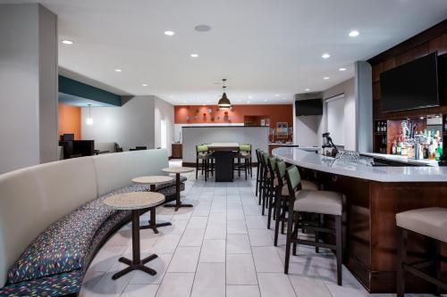 a restaurant with a bar with stools at Holiday Inn - Gulfport-Airport by IHG in Gulfport