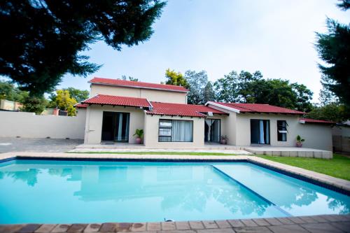 a house with a swimming pool in front of it at Prestigious Apartments in Fourways