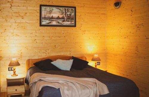 a bedroom with a bed in a wooden wall at Vándor Tanya in Ágasegyháza