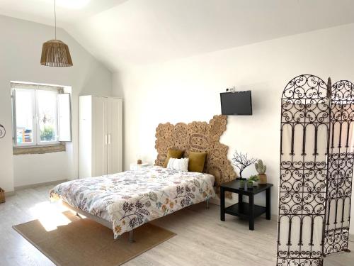 um quarto com uma cama e uma TV na parede em Casa da Tia em Sesimbra