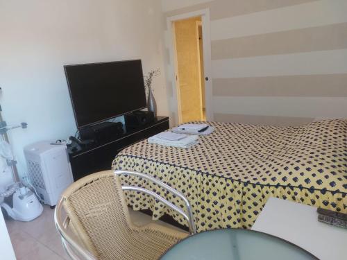 a room with a table with a television and a table with chairs at Cantinho da Lena in Sacavém