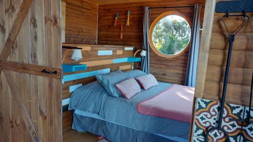 1 dormitorio con 1 cama en una cabaña de madera en Cabañas & SPA Carilafquen en Laguna Verde