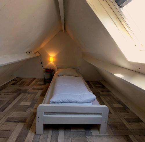 カラントスウオーフにあるZwaan's Placeの窓付きの屋根裏部屋の小さなベッド1台