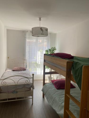 2 beliches num quarto com uma janela em Bel appartement de 65 m2 em Saint-Denis