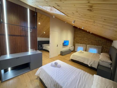 1 dormitorio con 2 camas y pared de ladrillo en Bujtina Apsus en Berat