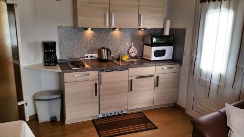 eine kleine Küche mit einer Spüle und einer Mikrowelle in der Unterkunft FeWo mit Terrasse - Apartment with terrace in Rockeskyll