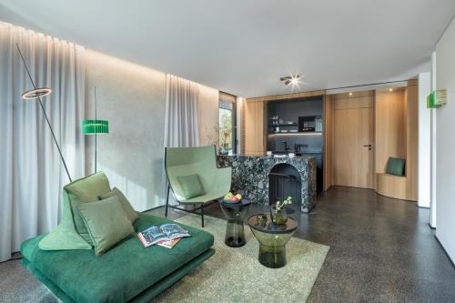 sala de estar con sofá verde y chimenea en Das Royal, en Bad Füssing