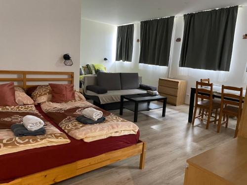 a bedroom with two beds and a living room at Hillside Strašín Šumava in Strašín