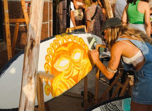 a woman painting a surfboard on a table at Seven Beach TLV - By 7even Hotels in Tel Aviv