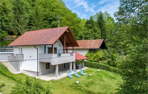a house with a red roof and blue chairs at Awesome Home In Ozalj With Kitchen in Ozalj