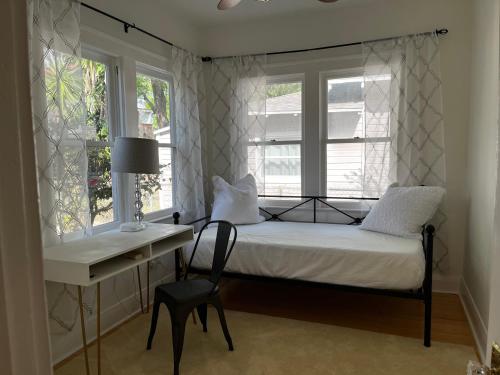 1 dormitorio con 1 cama, escritorio y ventanas en Southern Charm in Lakeland en Lakeland