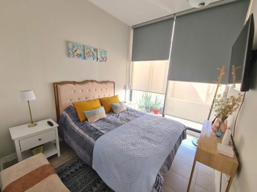 a bedroom with a bed and a large window at Depto nuevo Full equipado - Estacionamiento - Plaza Egaña, Ñuñoa in Santiago