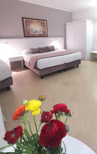 a bedroom with a bed and a vase of flowers at Hotel Centrale Spa & Relax in Alcamo