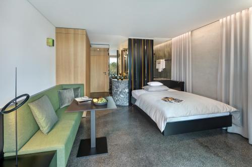 バート・フュッシンクにあるDas Royalのベッドルーム1室(ベッド1台、テーブル、ソファ付)