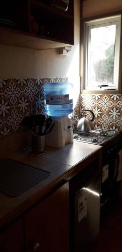 a kitchen counter with a stove and a window at Cabañas & SPA Carilafquen in Laguna Verde