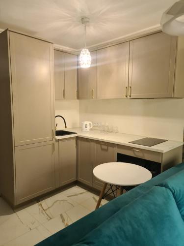 a kitchen with white cabinets and a table and a stool at Apartament Zegrzyński z widokiem in Serock