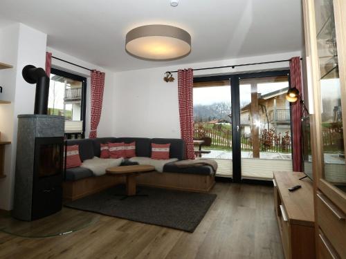 a living room with a couch and a fireplace at Chalet Alpenzauber mit beheiztem Pool, Inzell in Inzell