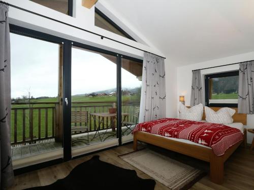 a bedroom with a bed and a balcony at Chalet Alpenzauber, Inzell in Inzell