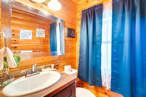 a bathroom with a sink and a blue shower curtain at Lovely Gatlinburg Cabin with Private Hot Tub! in Gatlinburg